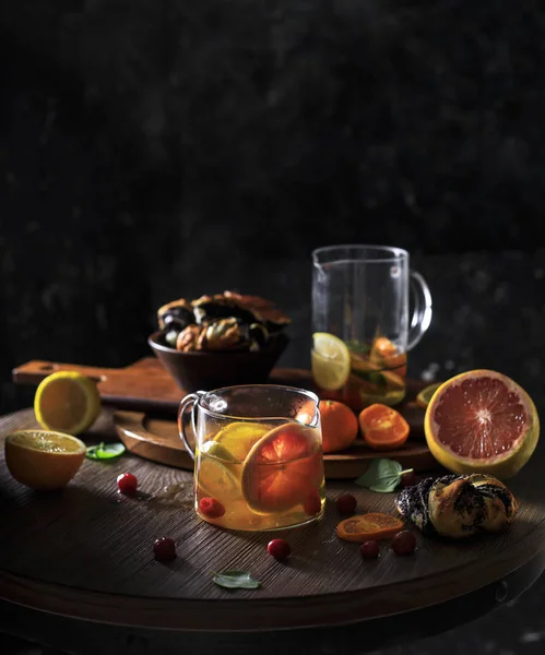 Rustik kış narenciye mulled şarap çay. Rustik koyu arka plan üzerinde buhar ile küçük su ısıtıcısı