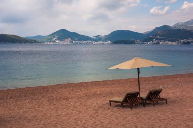 Şezlong ve şemsiye Adriyatik Denizi üzerinde sahilde Budva, Karadağ yakın: