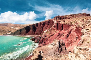 Ünlü Red Beach (Akrotiri) Santorini, Yunanistan ile turkuaz su ve mavi gökyüzü ve bulutlar 