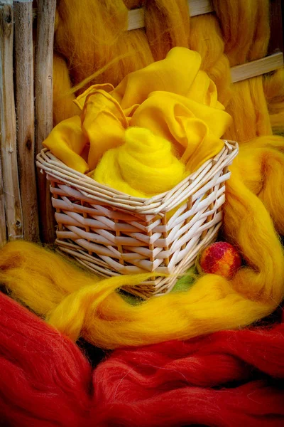 フェルトの色のウールの背景に黄色い布付きバスケット — ストック写真