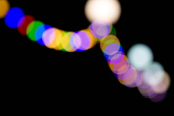 Věnec z vícebarevné světlo žárovky v rozostření — Stock fotografie