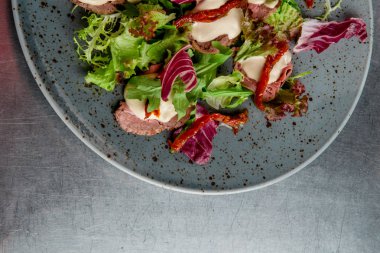 salata ve güneşte kurutulmuş domates gri plaka ile sığır eti