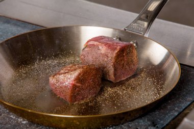 bir restoranda bir tavada sığır eti biftek kızarmış