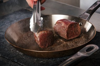 bir restoranda bir tavada sığır eti biftek kızarmış