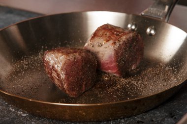 bir restoranda bir tavada sığır eti biftek kızarmış