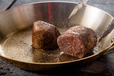 bir restoranda bir tavada sığır eti biftek kızarmış