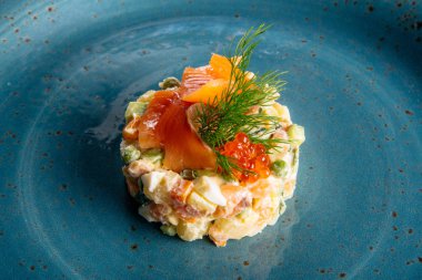 Somon ve yumurta ile mavi tabakta Rus salatası