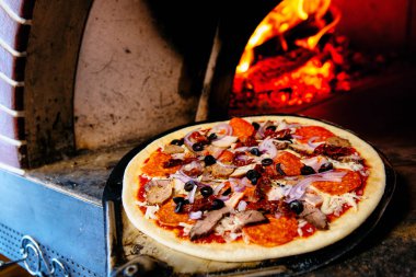 Salamlı pizza masada.