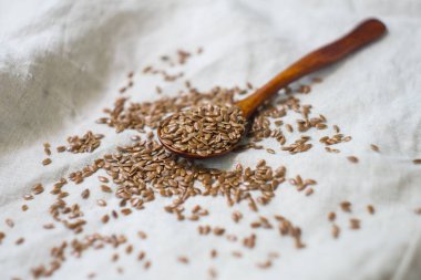 İçinde bir tahta kaşık keten tohumu keten masa örtüsü serpilir
