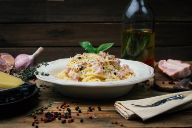 Spagetti Carbonara. Makarna alla carbonara bir krema sos, pastırma ve beyaz tabakta biber ile. Eski ahşap arka plan. Kopya alanı.