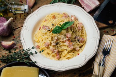 Spagetti Carbonara. Makarna alla carbonara bir krema sos, pastırma ve beyaz tabakta biber ile. Eski ahşap arka plan