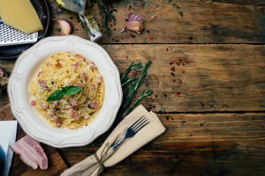 Spagetti Carbonara. Makarna alla carbonara bir krema sos, pastırma ve beyaz tabakta biber ile. Eski ahşap arka plan. Kopya alanı.