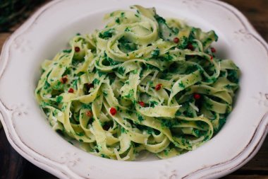 Ispanak Fettuccine. Vejetaryen Makarna ıspanak (ıspanak Fettuccine Alfredo makarna) beyaz tabakta ile. Eski ahşap arka plan