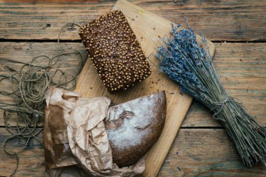 Ev yapımı çavdar karanlık ekmek kişniş ve rustik ahşap masa arka plan üzerinde Lavanta.