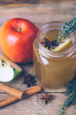 Tarçın ve ahşap zemin üzerine taze elma ile elma suyu (sıcak elma şarabı). Sonbahar içer. Kış ruh hali.