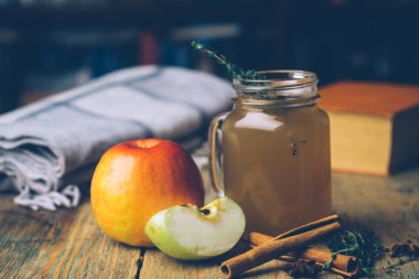 Tarçın ve ahşap zemin üzerine taze elma ile elma suyu (sıcak elma şarabı). Sonbahar içer. Kış ruh hali.