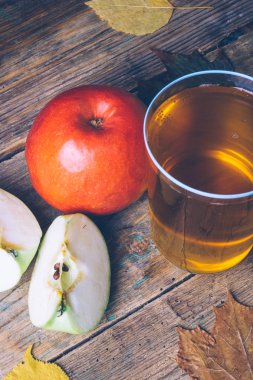 Soğuk elma veya elma suyu ile ahşap arka plan üzerinde taze elma. Sonbahar içer. Sonbahar ruh hali.