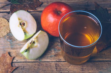 Soğuk elma veya elma suyu ile ahşap arka plan üzerinde taze elma. Sonbahar içer. Sonbahar ruh hali.