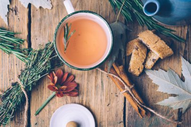 Biberiye ve kekik bitkisel çay düşmek. Çaydanlık, Kupası, otlar ve yaprakları eski ahşap arka plan. Sakin ve huzurlu ruh hali.