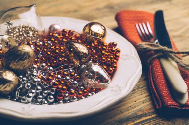 Tatil Noel yemeği arka plan kavramı. Beyaz bir tabak ve Noel süslemeleri Noel tablo. Çatal bıçak ve çatal kırmızı peçeteye kümesi. Eski rustik klasik ahşap arka plan. Kopya alanı.