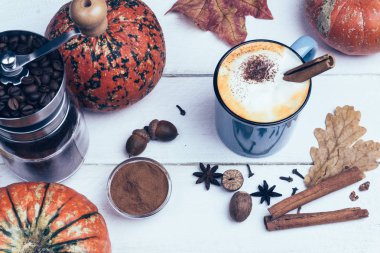 Kabak spice latte veya kahve tarçın ve Hindistan cevizi. Sonbahar, sonbahar ya da kış sıcak içecek. Eski sarı yapraklar ve kabaklar ahşap arka plan beyaz
