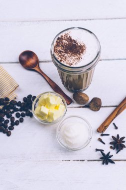 Kurşun geçirmez kahve. Ketogenic diyet kahve Hindistan cevizi yağı ve tereyağı (ghee). Kurşun geçirmez kahve ve malzemeler, paleo diyet fincan. Beyaz ahşap arka plan üzerinde