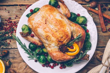 Noel tavuk Brüksel lahanası ve rustik ahşap bir masa üzerinde baharatlar kavrulmuş. Noel akşam yemeği ya da akşam yemeği kavramı arka plan ile sonbahar yaprakları. Noel tablo ayarı arka plan.