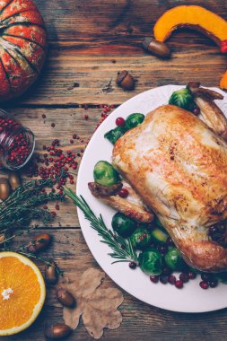 Noel tavuk Brüksel lahanası ve rustik ahşap bir masa üzerinde baharatlar kavrulmuş. Noel akşam yemeği ya da akşam yemeği kavramı arka plan ile sonbahar yaprakları. Noel tablo ayarı arka plan.