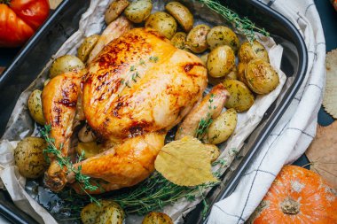 Kekik ile kavrulmuş tavuk patates, portakal ve baharat ahşap masa üzerinde siyah pişirme çanağı yılları arasında görev yapmıştır. Şükran veya Noel akşam yemeği. Üstten görünüm