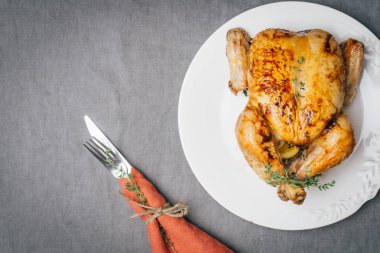 Kekik ile kavrulmuş tavuk patates, portakal ve baharat gri masa örtüsü üzerinde beyaz tabakta servis. Şükran veya Noel akşam yemeği. Üstten görünüm