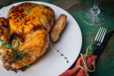 Kekik ile kavrulmuş tavuk patates, portakal ve baharat ahşap masa üzerinde beyaz tabakta servis. Şükran veya Noel akşam yemeği. Üstten görünüm