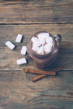Fincan sıcak kakao ya da sıcak çikolata şekerleme ve tarçın ile ahşap arka plan üzerine yapışır. Kış ruh. Alan kopyalama.