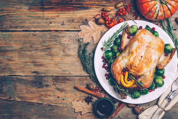  Brüksel lahanası ve rustik ahşap bir masa üzerinde baharatlar kavrulmuş tavuk. Şükran akşam yemeği ya da akşam yemeği kavramı arka plan ile sonbahar yaprakları. Şükran günü tablo ayarı arka plan.