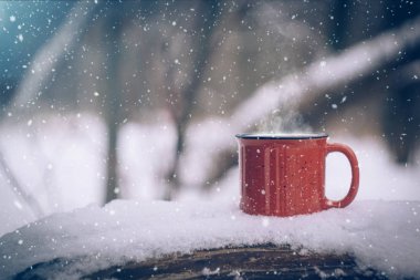 Mulled şarap kırmızı bir fincan. Karlı kış orman soğuk havalarda sıcak kış içkide açık. Kar taneleri ile Noel arka plan