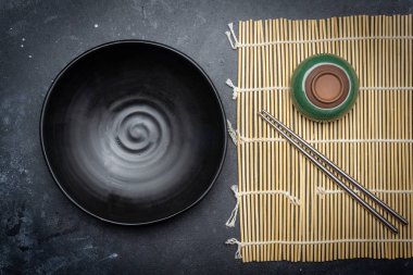 Boş tabak (karanlık) ve karanlık bir arka plan üzerinde Çin yemek çubukları. Asya tarzı, Asya mutfağı. Kopya alanı.