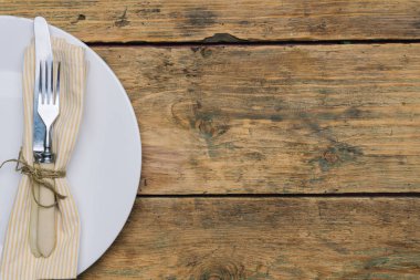 Bıçak, çatal ve peçete ile eski ahşap arka plan boş beyaz rustik plaka. Rustik gıda kavramı. Kopya alanı