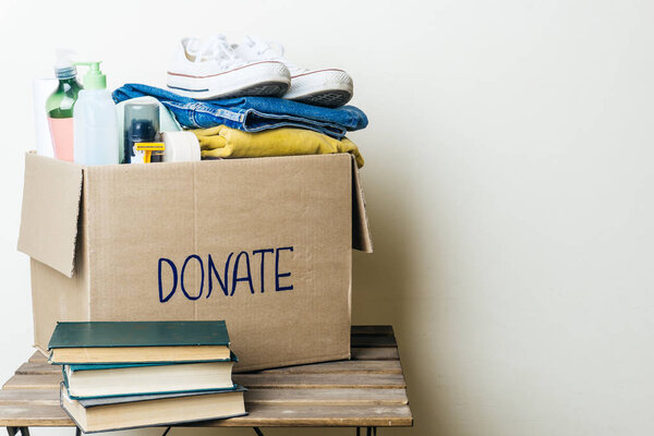 CLOTHES DONATION AND FOOD DONATION CONCEPT. Donation box with clothes and hygiene products. Copy space