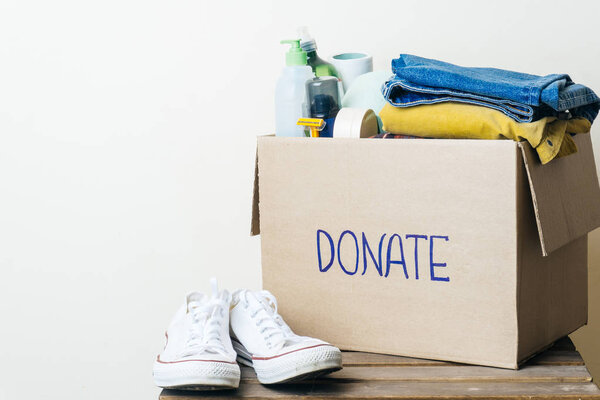 CLOTHES DONATION AND FOOD DONATION CONCEPT. Donation box with clothes and hygiene products. Copy space