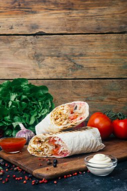 Hünkar (shawarma veya döner sarma). Lavaş (pita ekmeği) ile taze sebze - domates, yeşil salata, ızgara tavuk biber. Eski ahşap arka plan. Orta Doğu mutfağı, Arapça lokanta