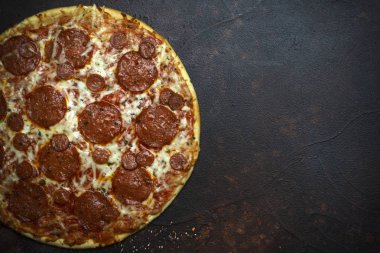 Koyu taş arka plan üzerinde İtalyan pizza pepperoni
