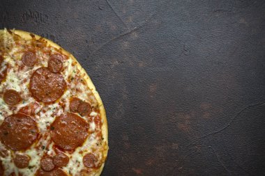 Koyu taş arka plan üzerinde İtalyan pizza pepperoni