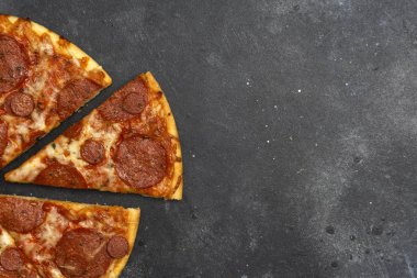 Koyu taş arka plan üzerinde İtalyan pizza pepperoni