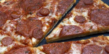 Gri taş arka plan üzerinde İtalyan pizza pepperoni