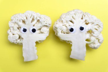 Komik yemek konsepti. Sarı arka planda karnabahar sebze. 