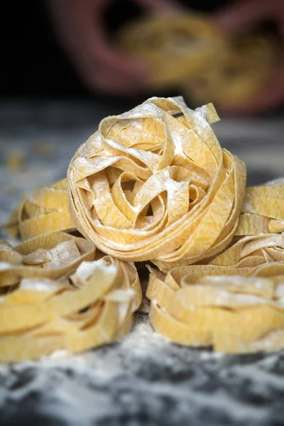 Kotitekoinen kypsentämätön pasta mustalla taustalla. Tuoreet italia — kuvapankkivalokuva