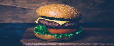 Ev yapımı Burger (cheeseburger) ahşap bir arka planda sığır eti ile