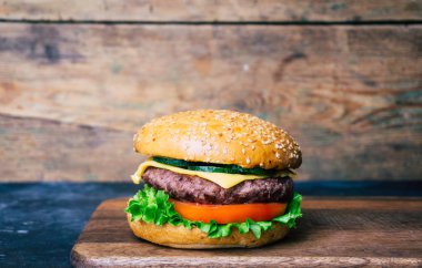 Ev yapımı Burger (cheeseburger) ahşap bir arka planda sığır eti ile