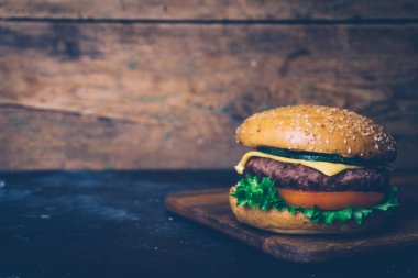 Ev yapımı Burger (cheeseburger) ahşap bir arka planda sığır eti ile