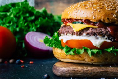 Ev yapımı Burger (cheeseburger) ahşap bir arka planda sığır eti ile