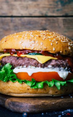 Ev yapımı Burger (cheeseburger) ahşap bir arka planda sığır eti ile